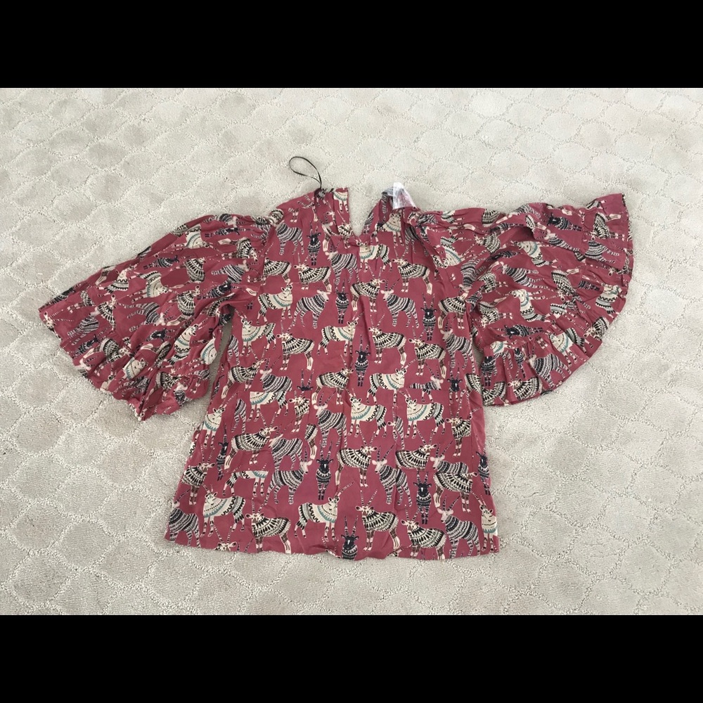 Pull over blouse with ruffled bell sleeves.